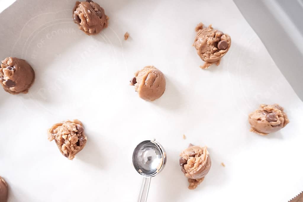 peanut butter chocolate chip cookie dough scooped onto tray