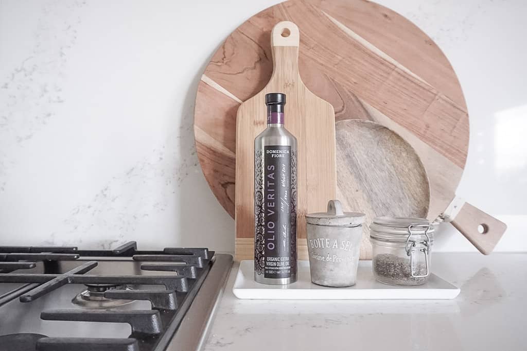 three wood cutting boards, olive oil, salt, and pepper on display next to the oven