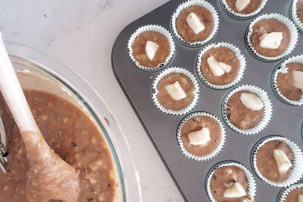 Batter in a bowl plus Signed Samantha's gluten free banana muffin batter in mini muffin tins with a 1/4 slice of banana sticking out