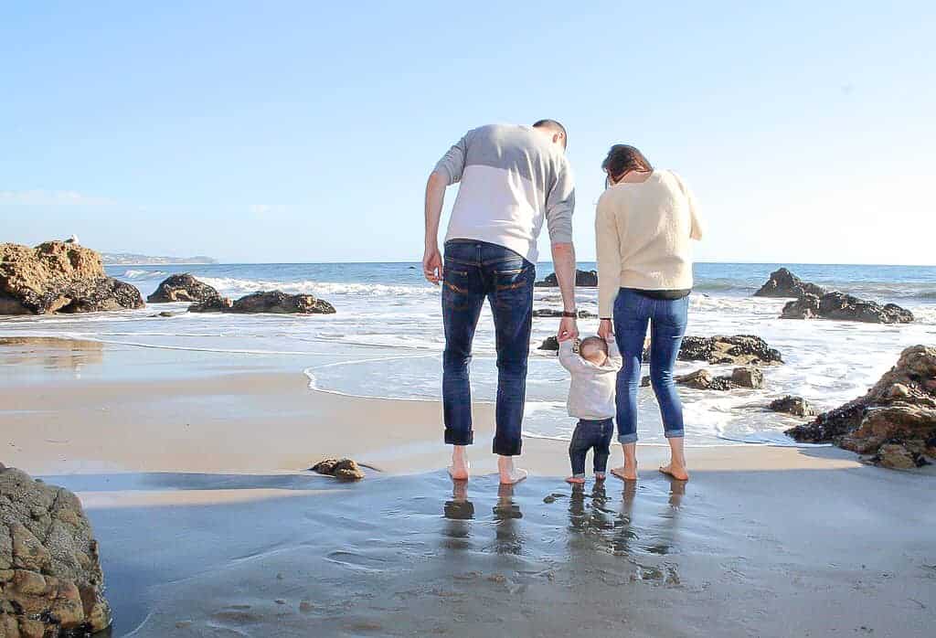 Signed Samantha's talking about what she's learned after three years of marriage while walking along the sandy beach with her daughter in the middle of her and her husband, holding both of their hands.