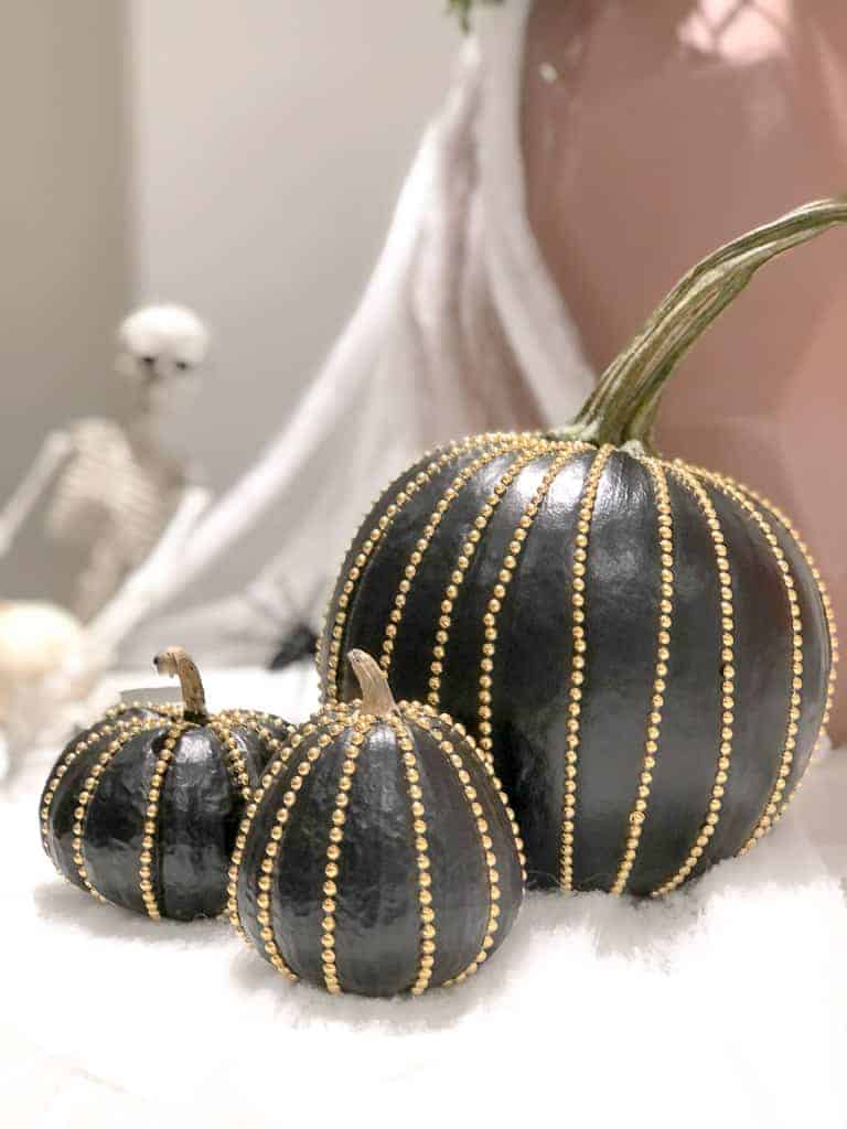 Signed Samantha's RockStud Pumpkins - three black pumpkins with gold rockstuds going around the pumpkin, from top to bottom