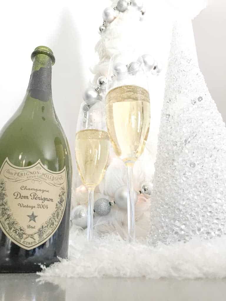 Signed Samantha's holiday gift guide 2020 for stocking stuffers and big gifts. Two small christmas trees and a bottle of champagne are pictured.