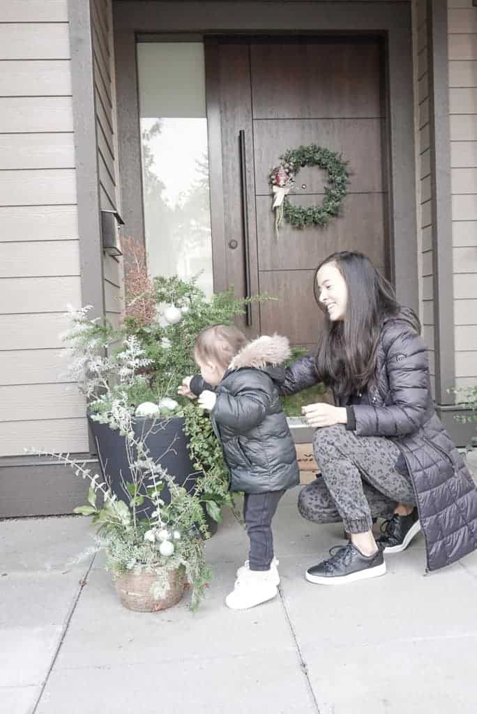 Signed Samantha shares her winter pot ideas - her and her daughter are pictured putting the greens in the pots together.