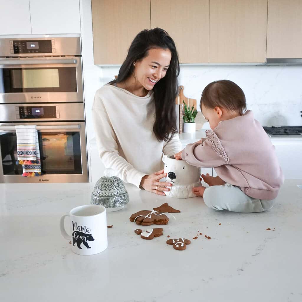 gluten free gingerbread cookies are on the counter and Signed Samantha's daughter is putting them into their cookie jar.