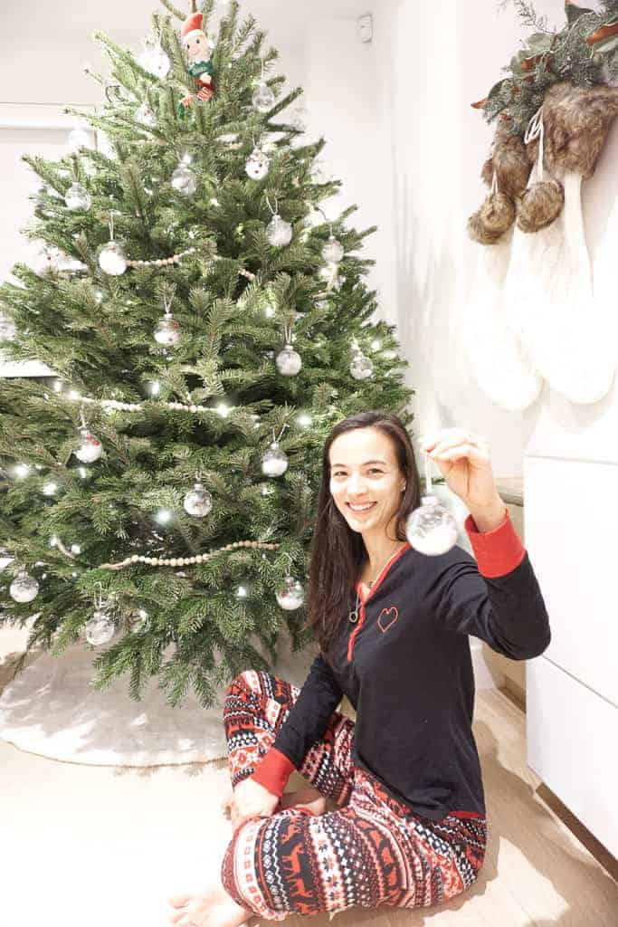 Signed Samantha holding up her D.I.Y Christmas ornament with greenery