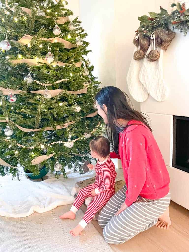 D.I.Y wood bead garland on Signed Samantha's Christmas Tree. Her and her daughter are sitting in front of the tree