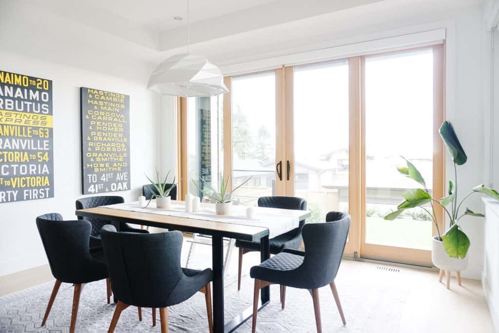 Signed Samantha's dining room tour - a view of her dining room with a carpet, white pendant light, plants, and bus rolls