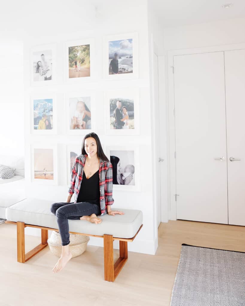 Signed Samantha sitting on her bench in front of her gallery wall - which happens to be one of her tips for a home decor refresh