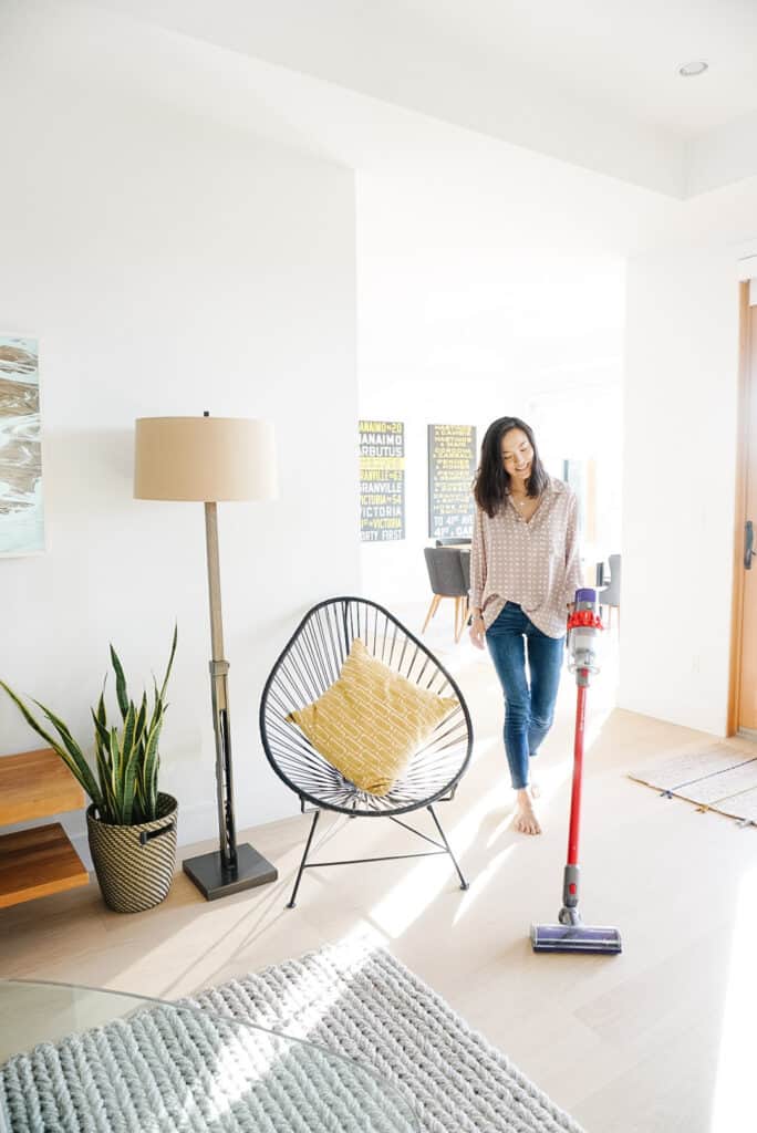 Signed Samantha sharing three things you need to clean - including your vaccum which is what Samantha is doing in this picture - vaccuming the floors of her house