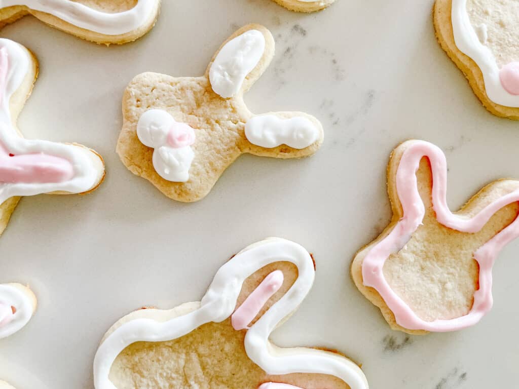 cute gluten-free sugar cookies shaped as bunny heads and decorated with pink and white icing