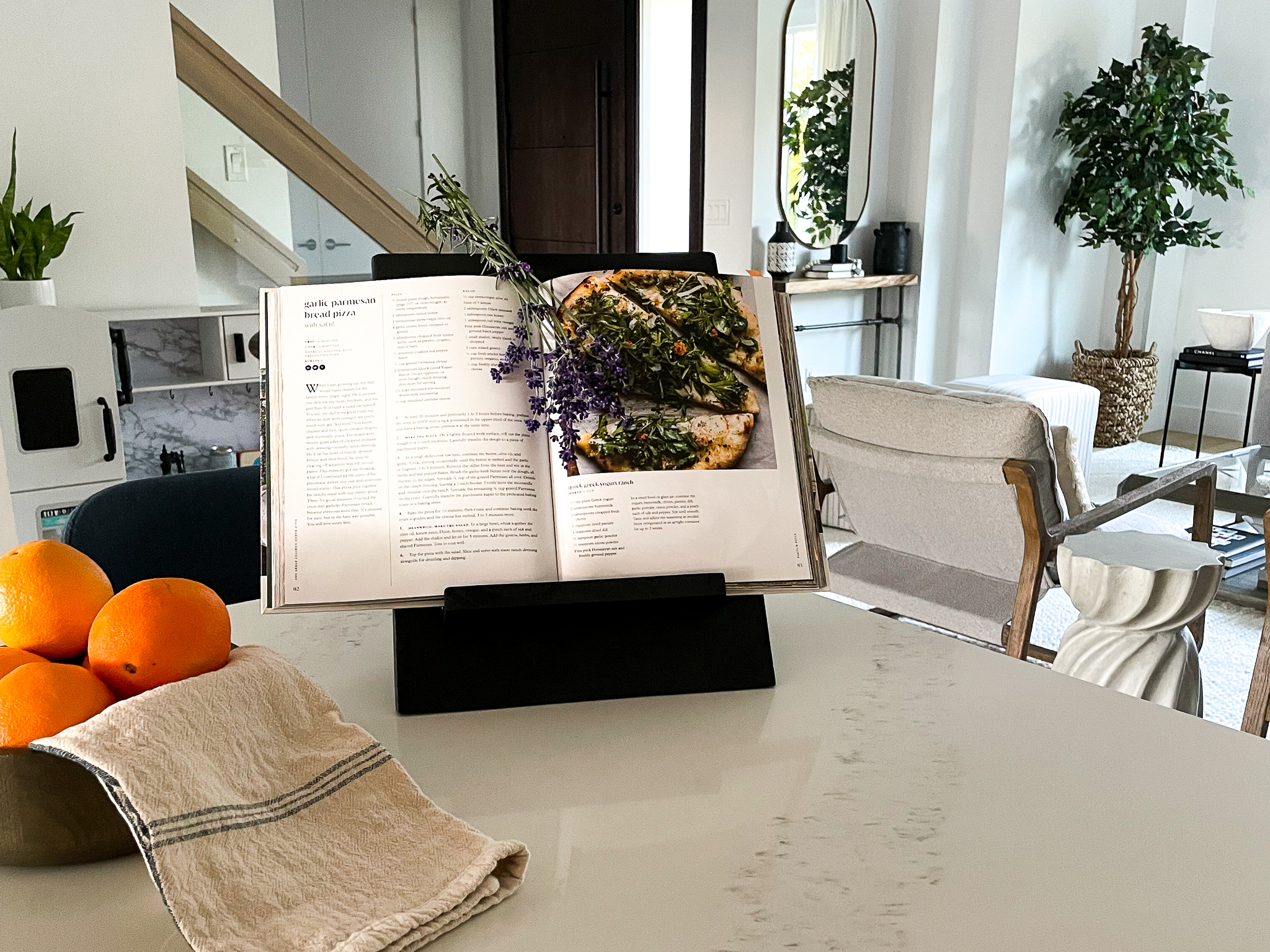 DIY cookbook holder sitting on a kitchen counter next to a bowl of oranges