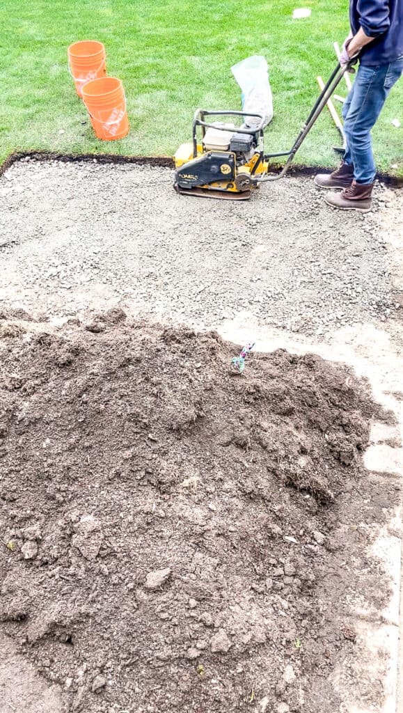 Signed Samantha explaining how to install patio paving stones including using a tamper over the gravel to compact it - which is what is pictured.