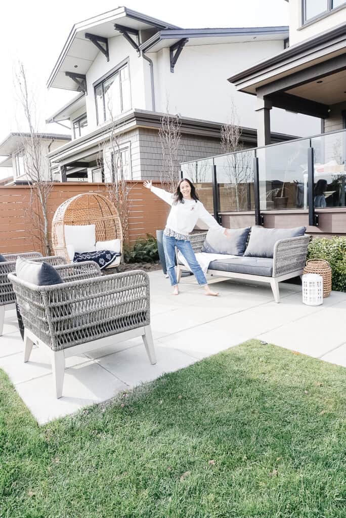 Signed Samantha standing on her freshly installed patio paving stones with her patio chairs and sofa set up as well