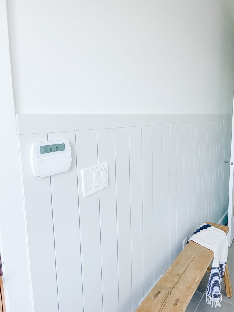 signed samantha did shiplap in her mudroom and this is one of the walls that's been done. shiplap is 4 ft up the wall and there is a bench in front of it.