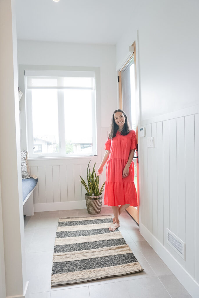 signed samantha in her mudroom standing in front of her newly diy shiplap walls.