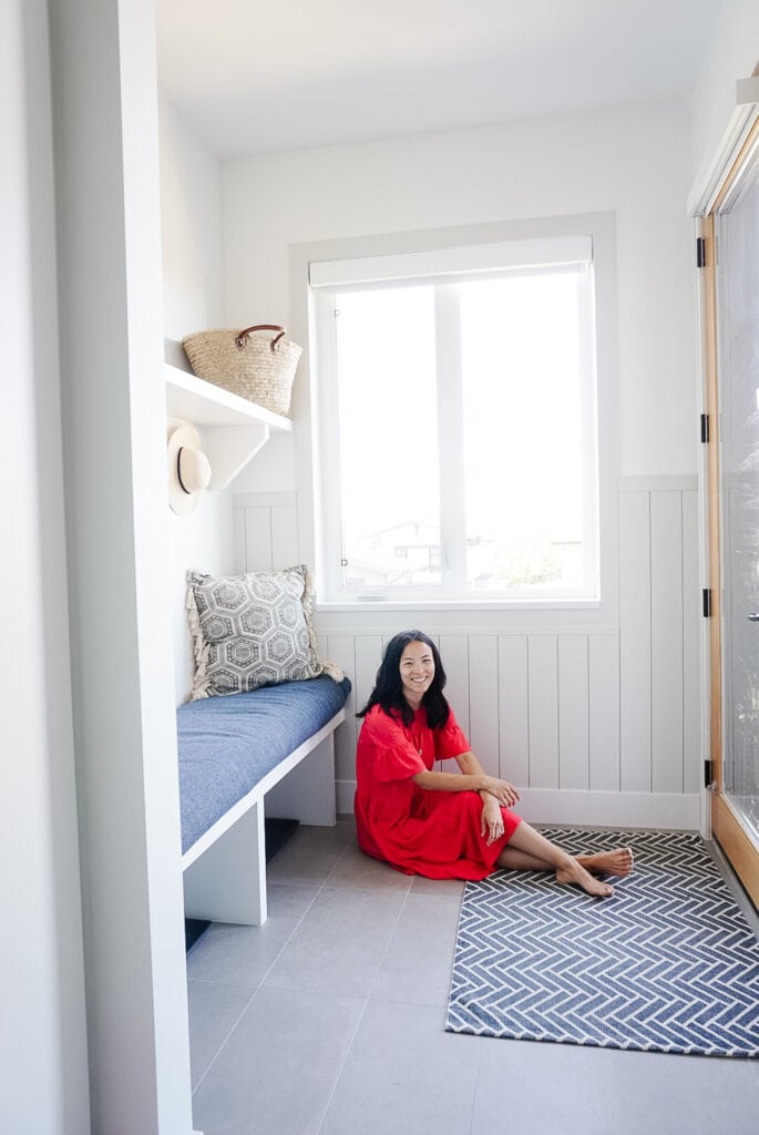 signed samantha sitting on her mudroom floor in front of her newly diy'ed shiplap wall