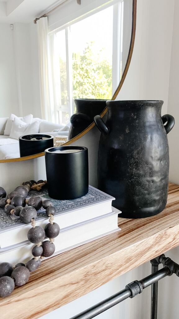 DIY antique vase sitting on top of a side table it is black and looks rustic and worn.