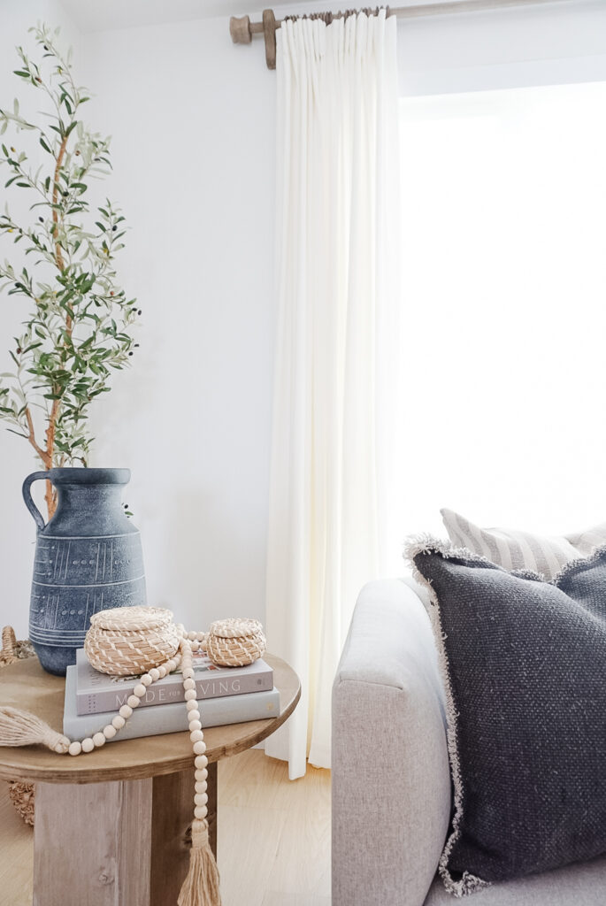 A close up of Signed Samantha's living room fall decor updates including a dark and moody vase and dark pillows.