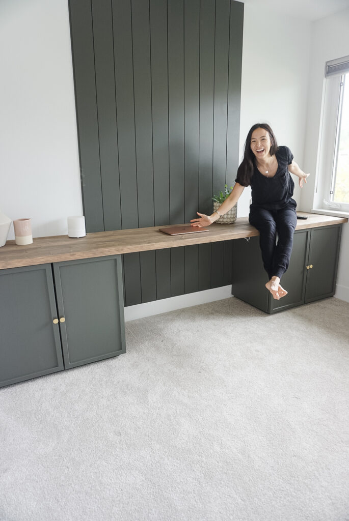 DIY Desk top for week 5 of the one room challenge - rusitc desktop, built in cabinets and a shiplap wall. Not yet done is a bookcase. There are small decor items on the desk and Signed Samantha sitting on the desk top.