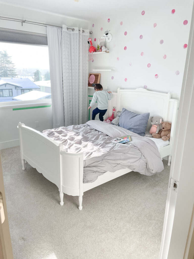 Sloane's nursery has transformed to a big girl bedroom with a wooden white bedframe and a double bed in the space.