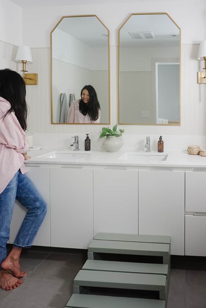 beadboard on this beautifully upgraded bathroom with gold mirrors and wall sconces.