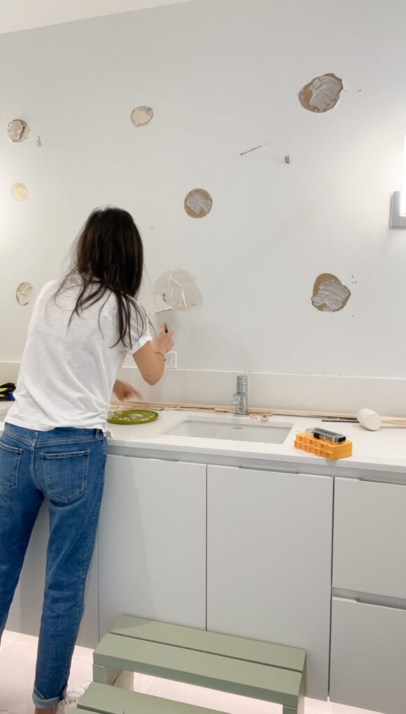 patching up holes on the wall from after teaching how to remove a builder grade mirror