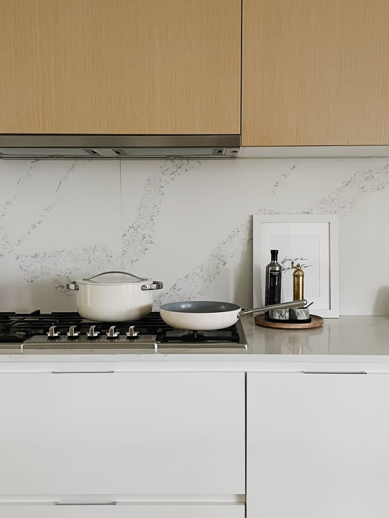 Caraway pots and pans pictured in a kitchen on the stovetop