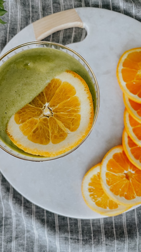 green smoothie, a bunch of sliced orange,