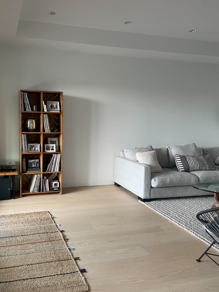 how to decorate a space - the before of a family room with a bookshelf that's too small and rug that's too small