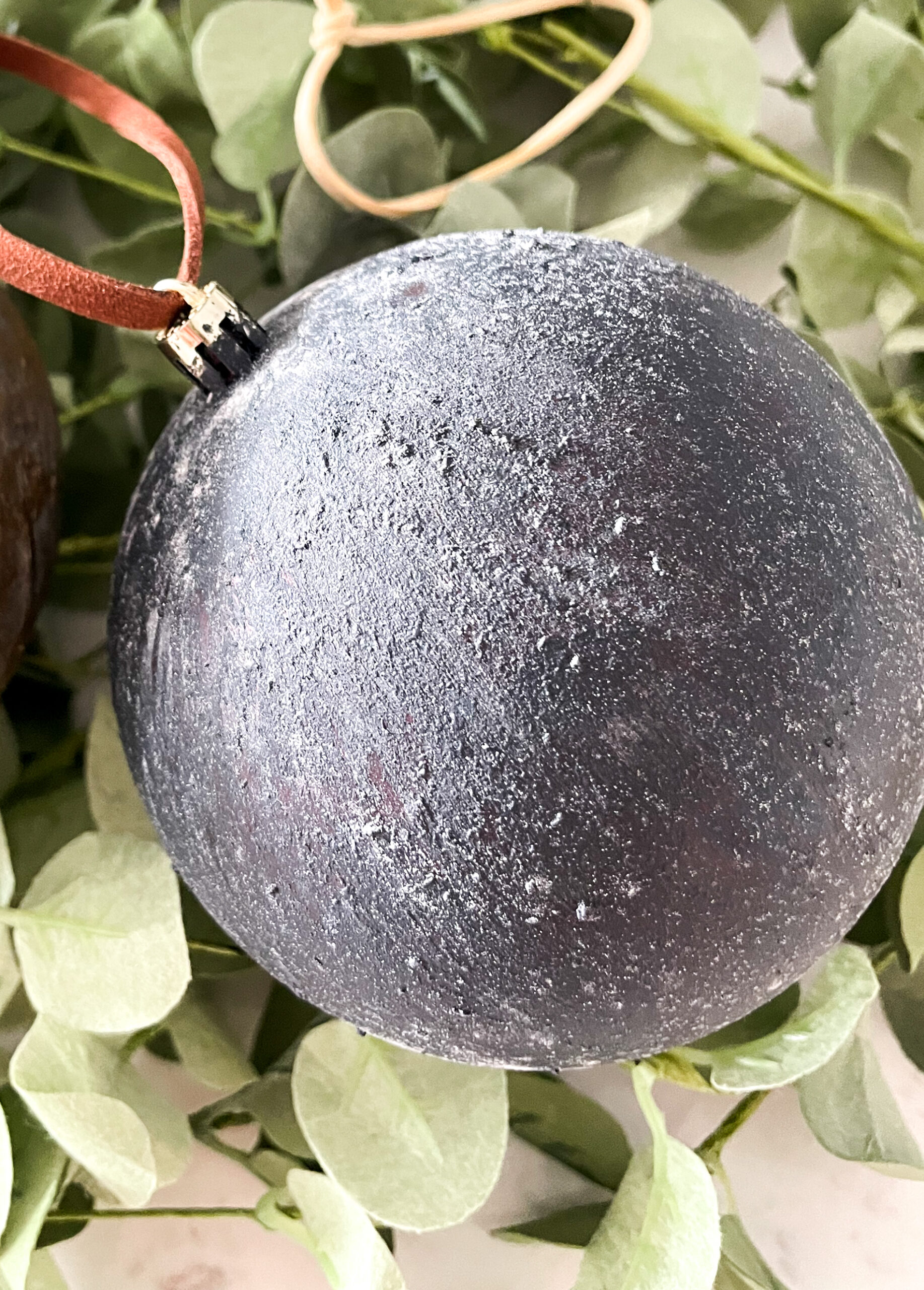 DIY Antiqued Christmas Ornaments on top of eucalyptus