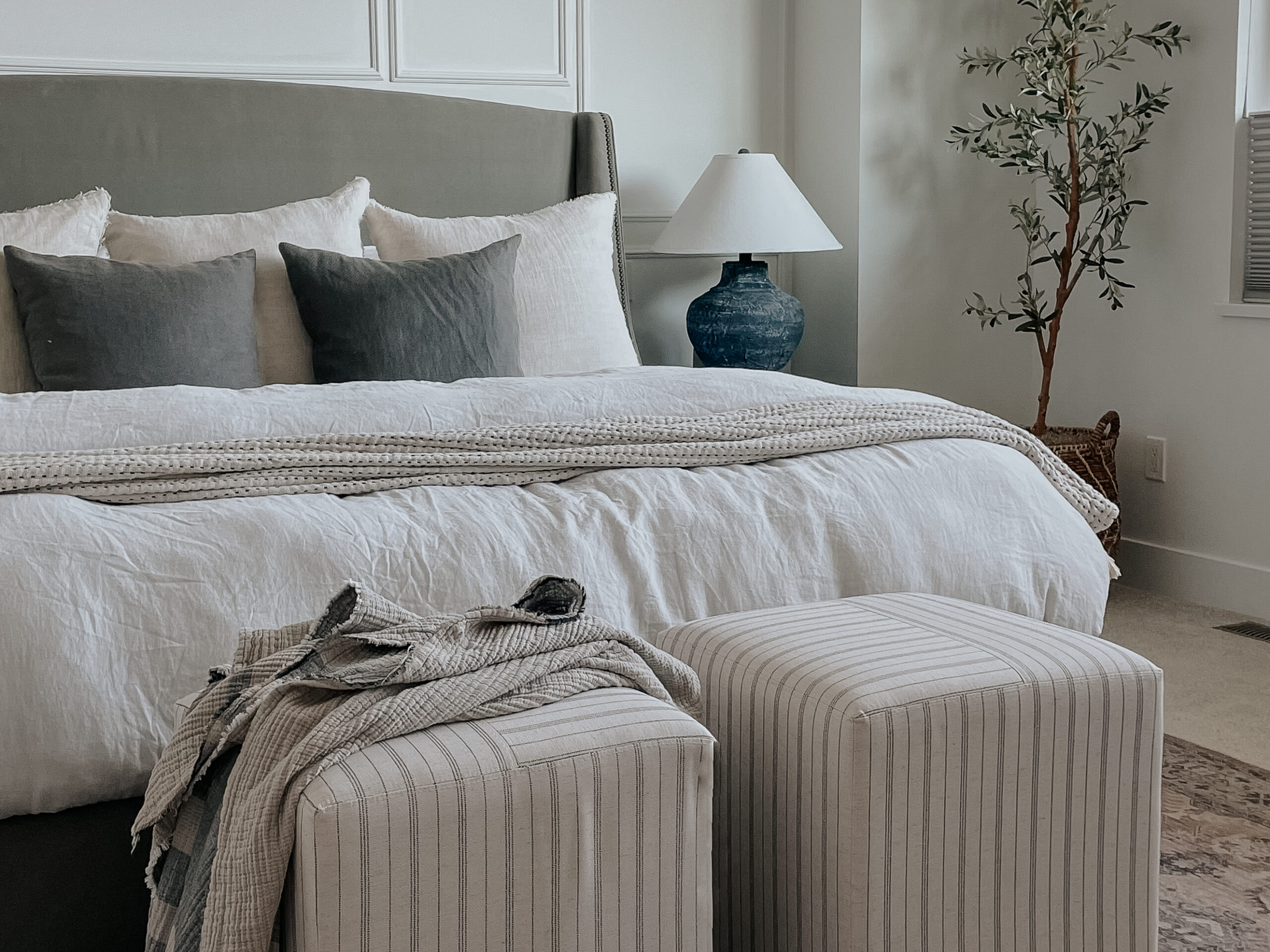 parachute bedding on top of a bed - linen duvet cover and duvet insert with stools at the bottom of the bed