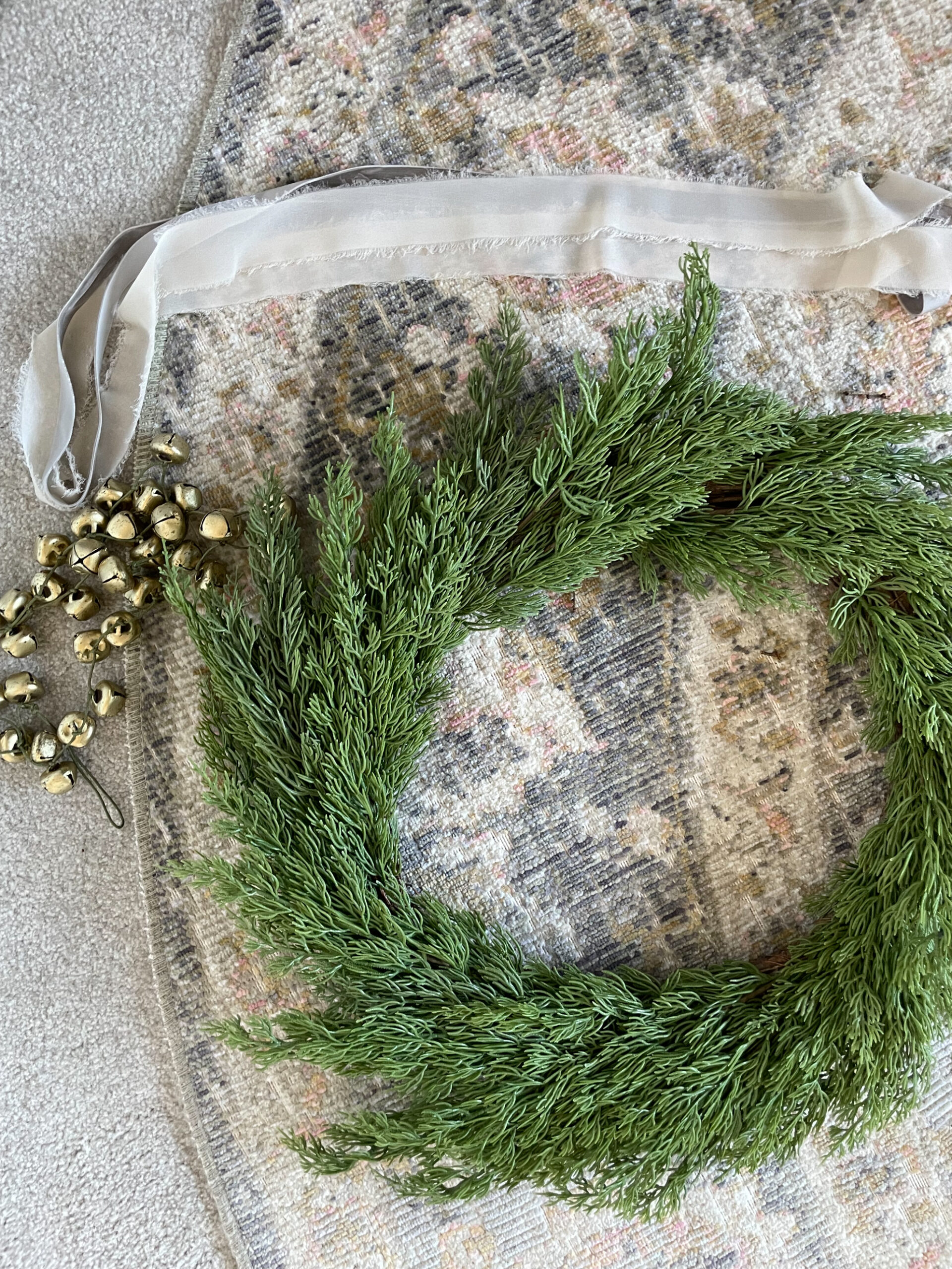 Wreath on the ground ready to be decorated with ribbons and bells