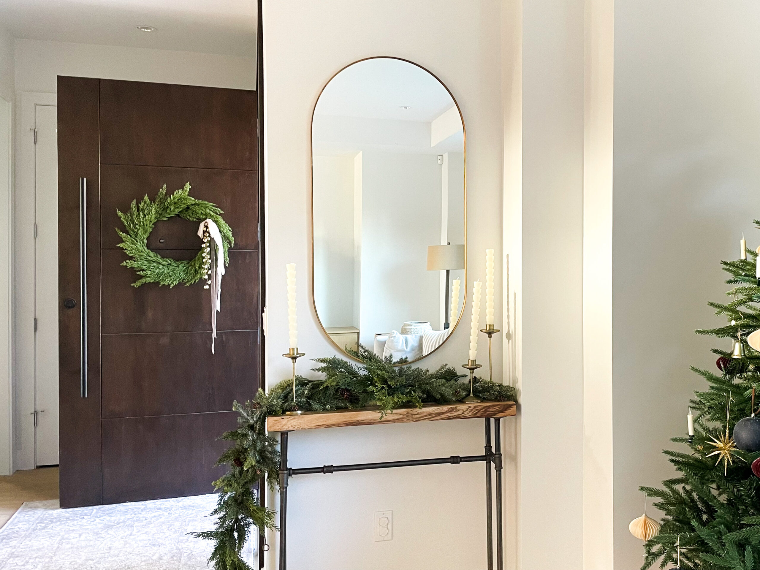 wreath hanging on the front door with ribbon and bells