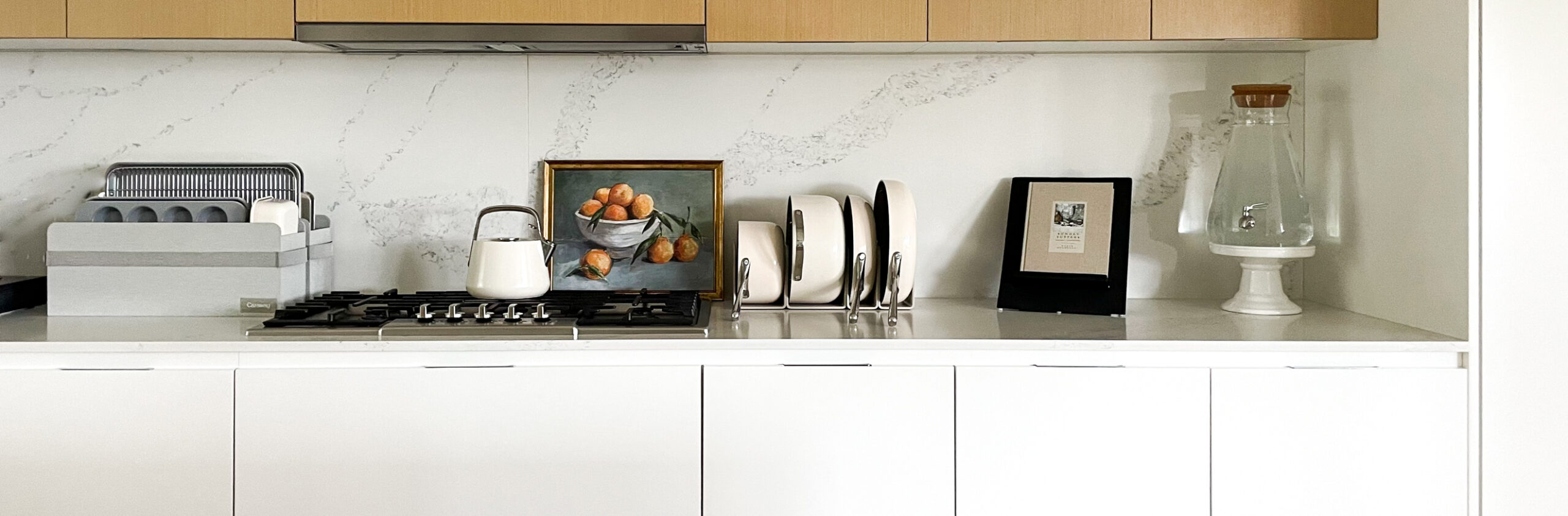 MY complete caraway kitchen pictured - a tea kettle, baking trays and dishes, and pots and pans