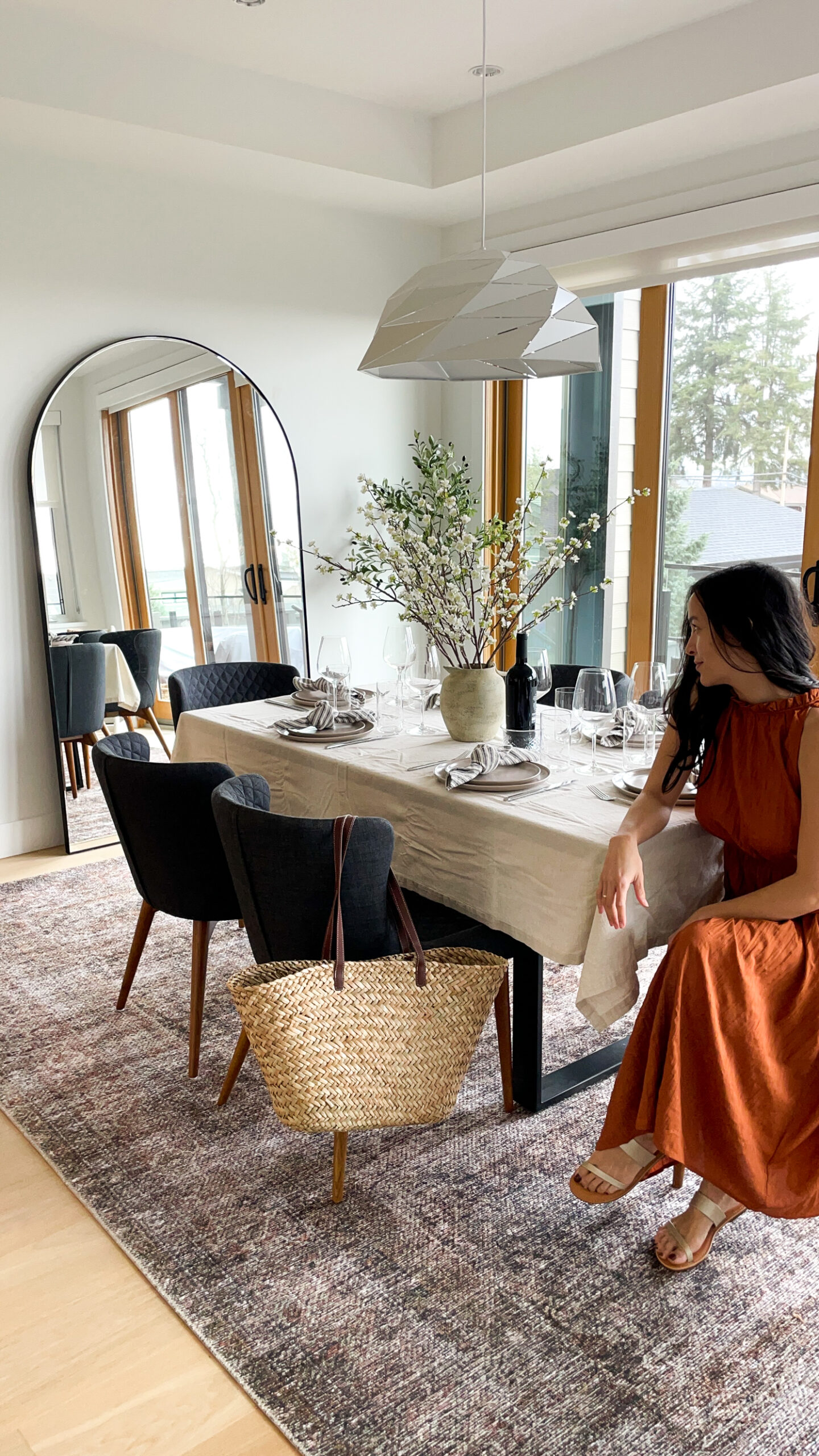 Signed Samantha sitting in the dining room with her spring gap clothes including a beautiful dress, market bag, and metallic sandals