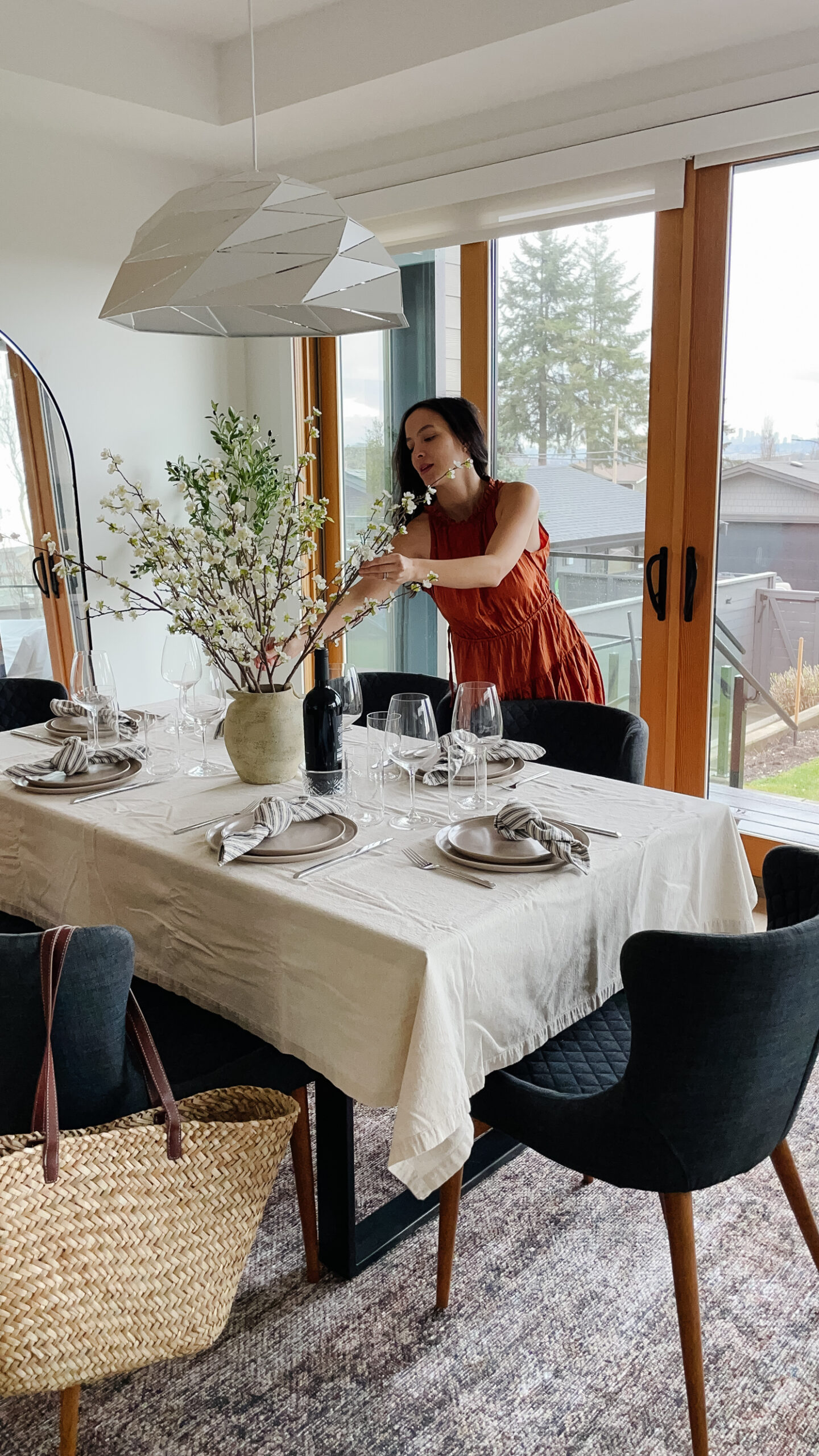 Signed Samantha sitting in the dining room with her gap clothes including a beautiful spring dress, market bag, and metallic sandals