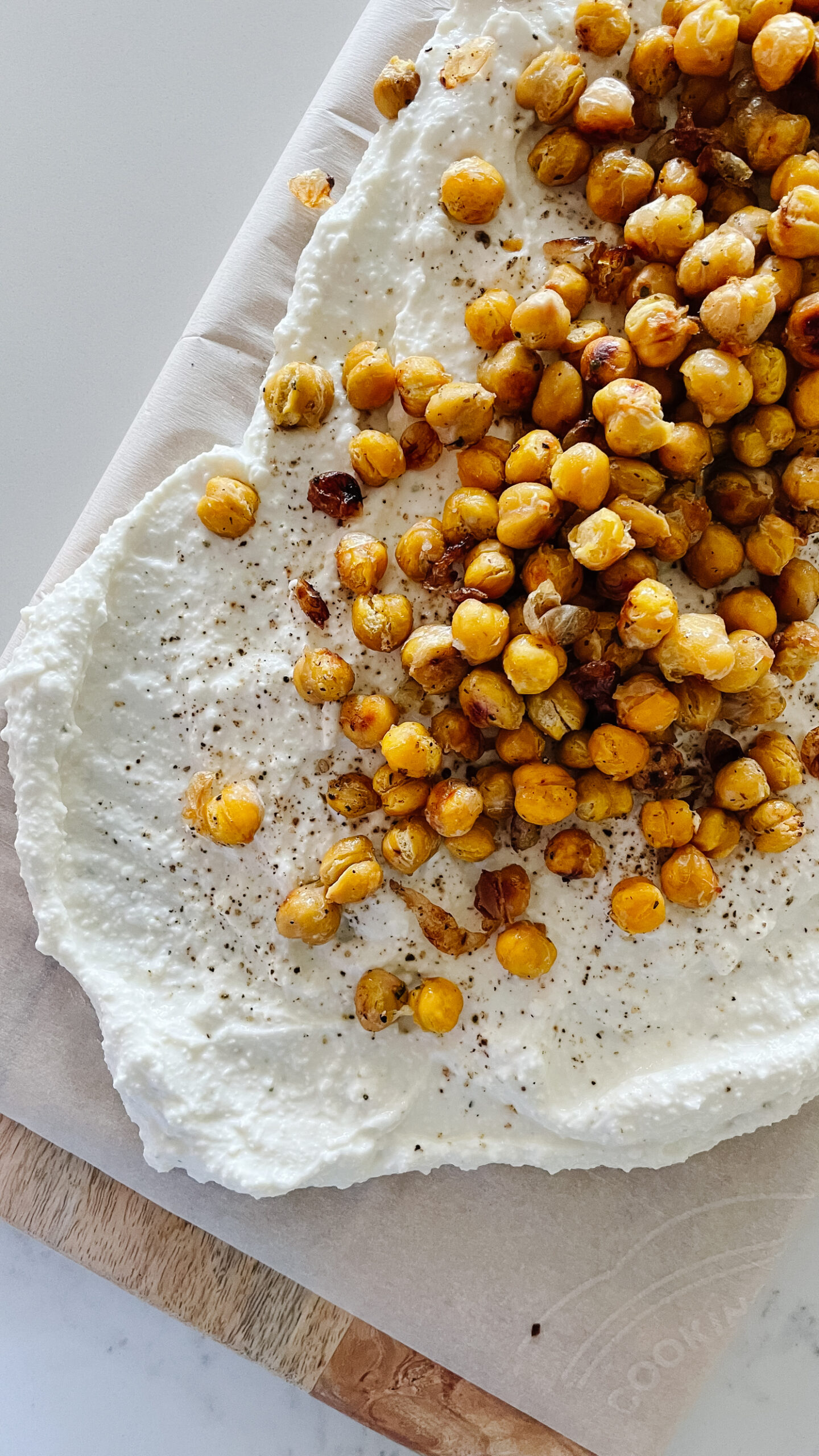 A delicious and simple honey whipped feta on a board with roasted chickpeas overtop