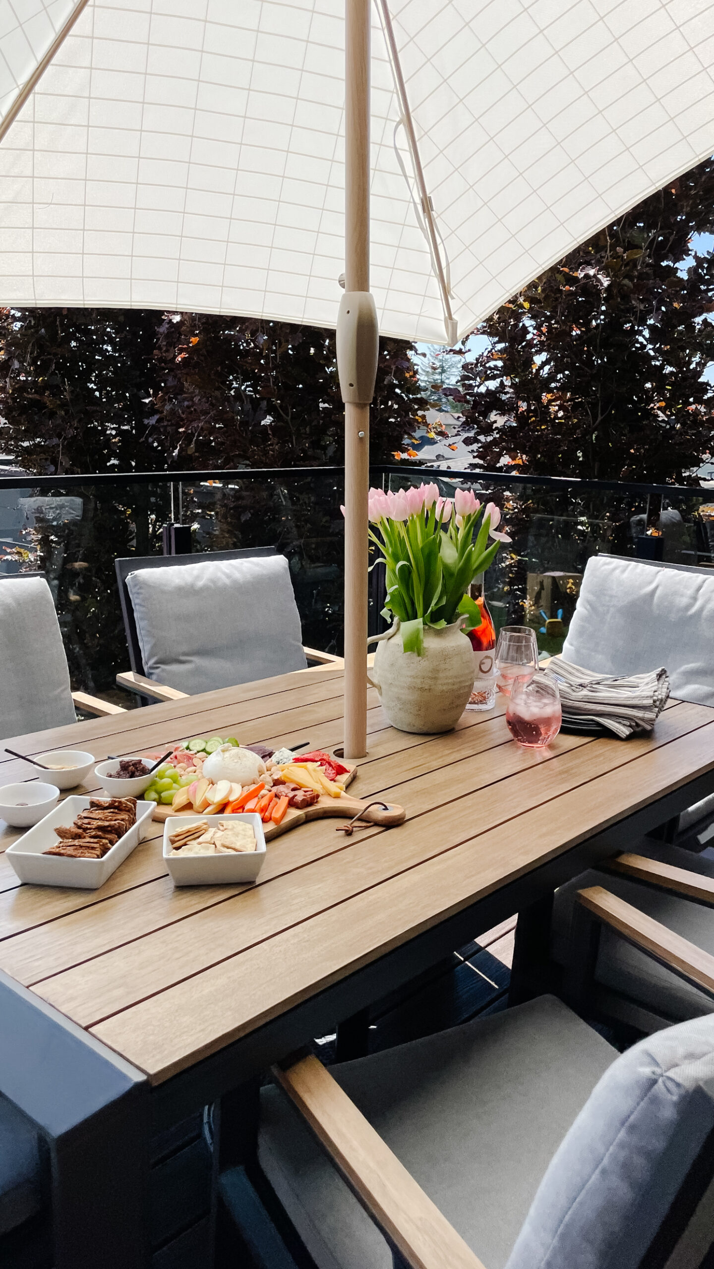 Upper deck of the backyard patio space with a dining table, food, and chairs - ready for entertaining