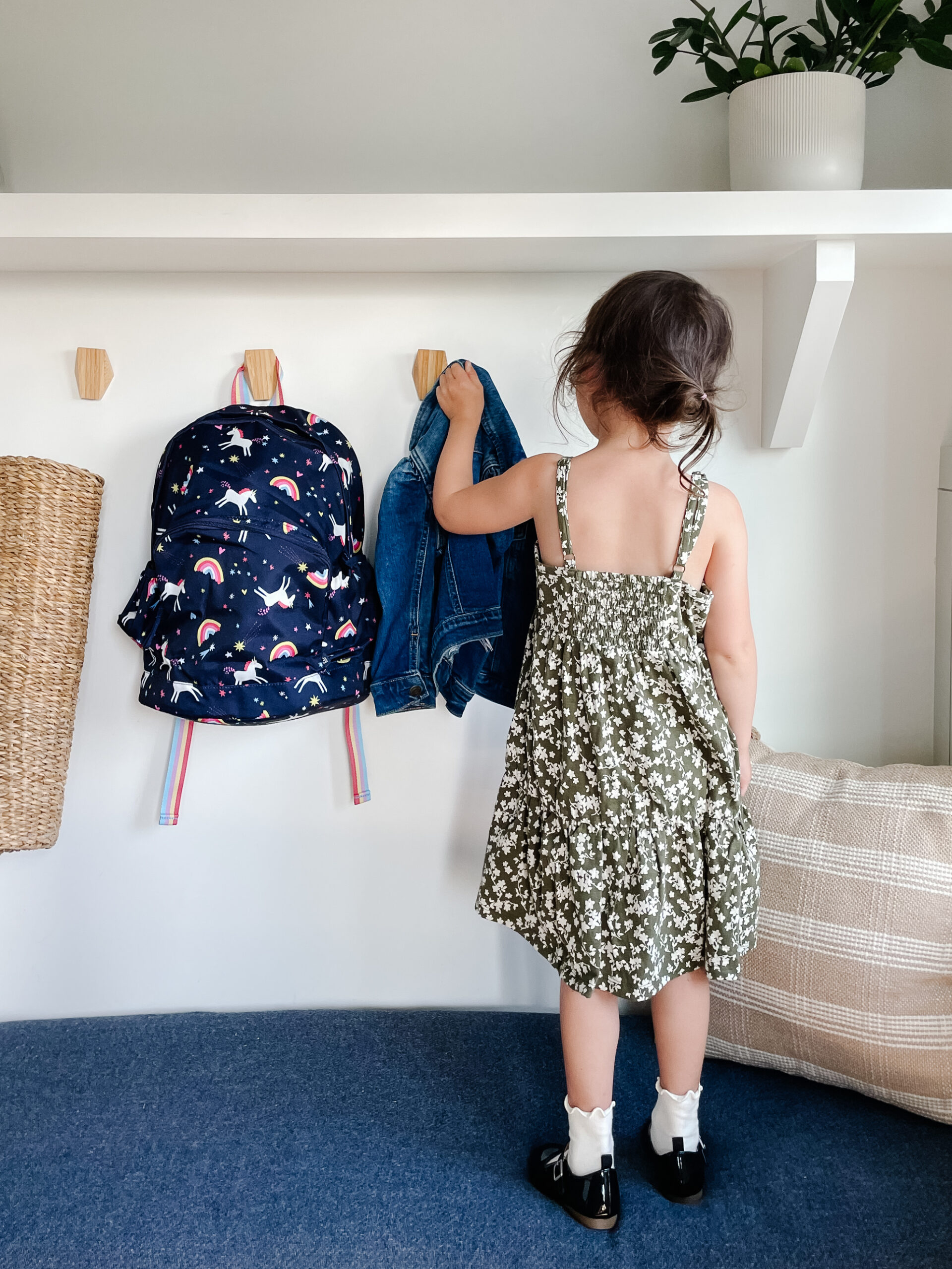 Little girl grabbing her jacket and back pack for back-to-school outfits with the Gap