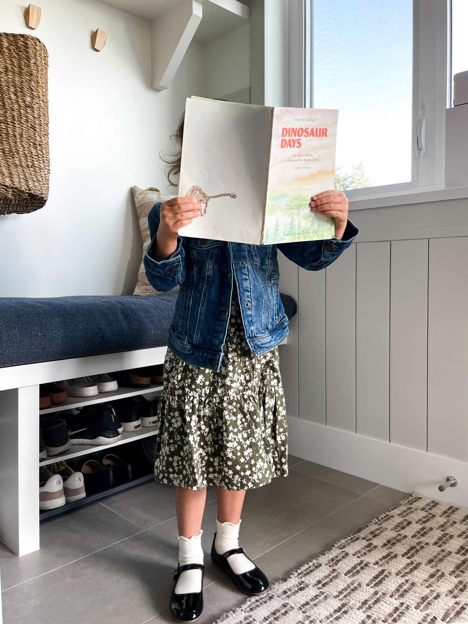 Little girl in her back-to-school outfit of a green flower dress and jean jacket