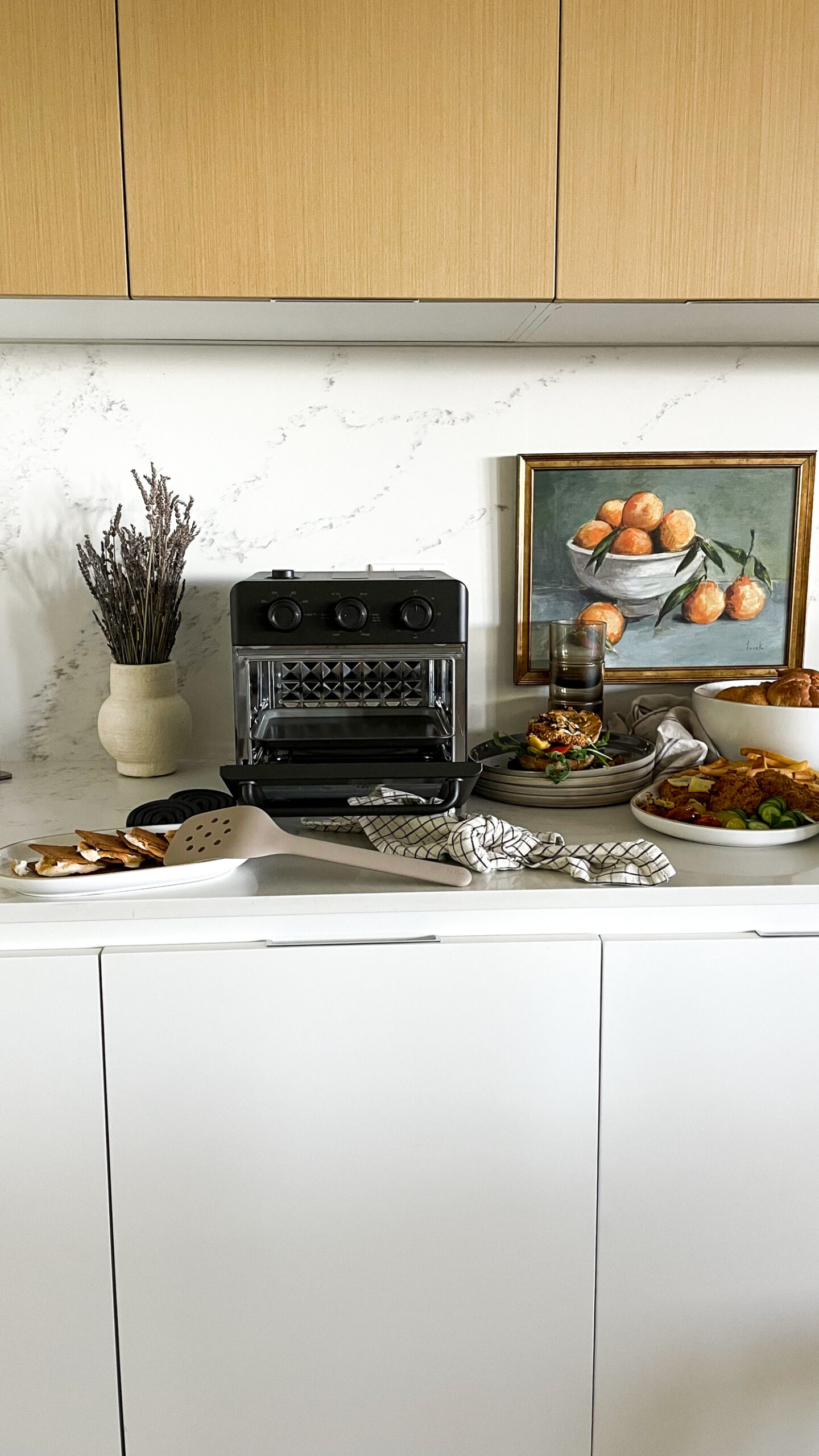 Our place wonder oven on the counter surrounded by delicious food all made in the oven