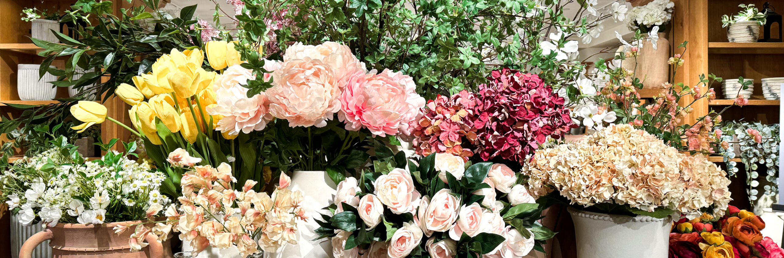 faux spring florals arranged in vases on a table. Peonies, roses, and more. so colourful and so beautiful.