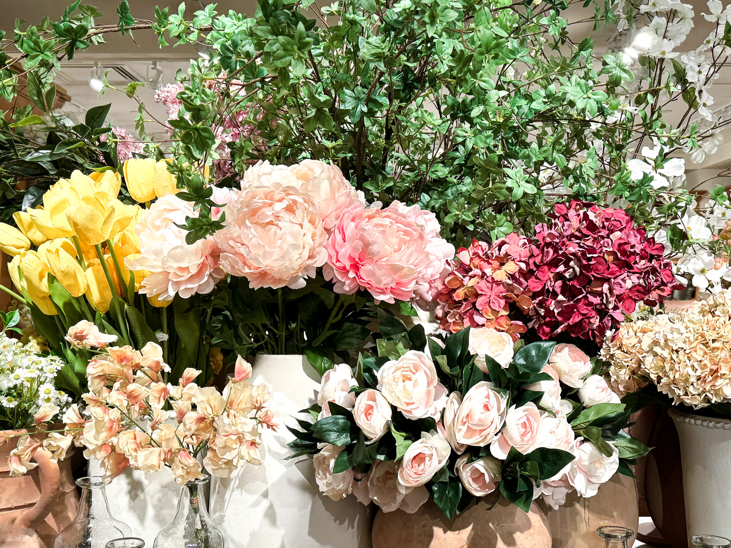 faux spring florals arranged in vases on a table. Peonies, roses, and more. so colourful and so beautiful.